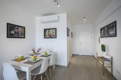 a white dining room with a white table and chairs at Mackenzie Zoe Seafront Suite in Larnaka