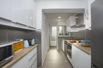 a kitchen with white cabinets and wooden counter tops at Mackenzie Zoe Seafront Suite in Larnaka