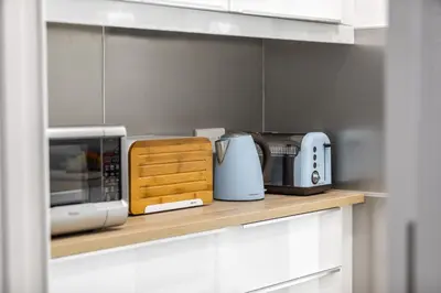 a kitchen counter with a microwave and other appliances at Mackenzie Zoe Seafront Suite in Larnaka