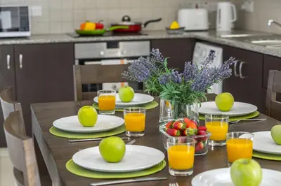 a table with plates of fruit and glasses of orange juice at Protaras Palm Suite in Protaras
