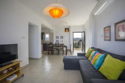 a living room with a couch and a television at Protaras Palm Suite in Protaras