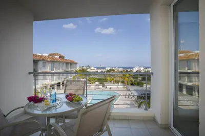 a balcony with a table with a bowl of fruit on it at Protaras Palm Suite in Protaras