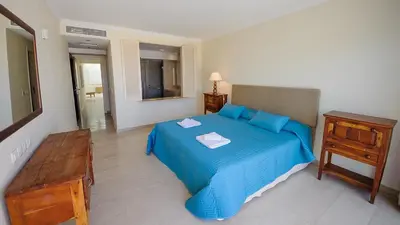 a bedroom with a blue bed with a dresser and a mirror at Luxury Bay View Villa 28 Right On The Beach in Protaras