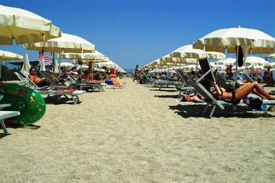 a group of people laying on the beach under umbrellas at Poseidon Boutique Apartment 1 in Limassol
