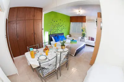 a living room with a dining table and a bedroom at Poseidon Boutique Apartment 1 in Limassol