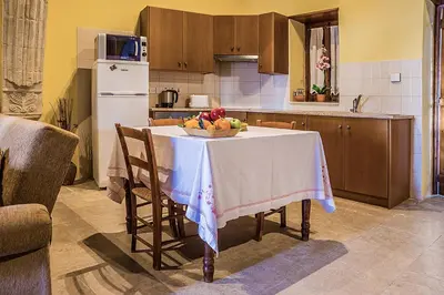 a kitchen with a table with a bowl of fruit on it at To Konatzi tou Flokka in Ayios Theodhoros