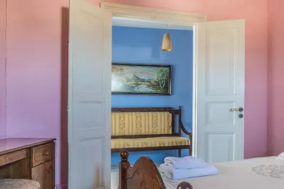 a room with a blue and pink wall with a chair at To Konatzi tou Flokka in Ayios Theodhoros