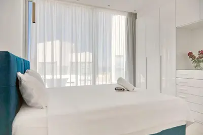 a white bedroom with a large white bed and a window at Seaview Luxury Villa Jacuzzi & Pool! 2 Min Beach in Protaras