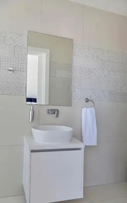 a white bathroom with a sink and a mirror at Seaview Luxury Villa Jacuzzi & Pool! 2 Min Beach in Protaras