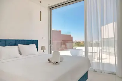 a bedroom with a white bed and a large window at Seaview Luxury Villa Jacuzzi & Pool! 2 Min Beach in Protaras