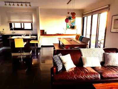 a living room with a couch and a table and a kitchen at Nicosia Cozy Nomad in Nicosia