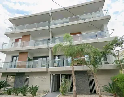 an apartment building with a balcony and palm trees at Nicosia Cozy Nomad in Nicosia