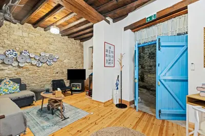 a living room with a blue door and a brick wall at RedBlue Door Two Traditional Listed Houses in Pano Lefkara