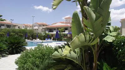 a resort with a swimming pool and some plants at Pyla Gardens A102 in Pyla