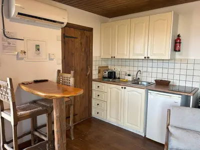 a kitchen with white cabinets and a wooden table at Pachna Studios - Village Life in Limassol