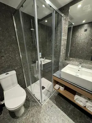a bathroom with a shower and a toilet and a sink at Sunflower Hotel Apartments in Larnaka