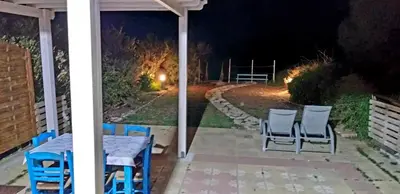 a table and chairs on a patio at night at Mariliz in Larnaka