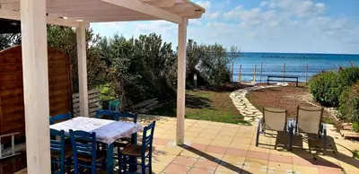 a patio with a table and chairs and the ocean at Mariliz in Larnaka