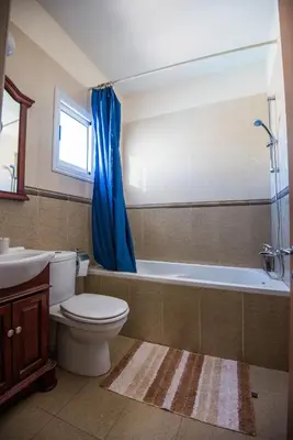 a bathroom with a toilet and a tub and a sink at Nissi Villa Crystal in Ayia Napa