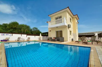 a villa with a swimming pool in front of a house at Nissi Villa Crystal in Ayia Napa