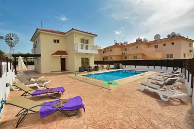 a villa with a swimming pool and lounge chairs at Nissi Villa Crystal in Ayia Napa