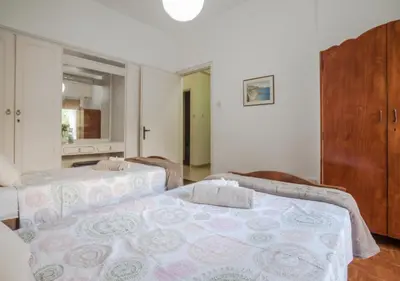a bedroom with two beds and a bathroom with a mirror at Sunny Family Home By The Beach in Limassol