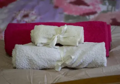 a pile of towels with bows on a bed at Sunny Family Home By The Beach in Limassol