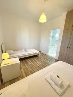 a white room with a bed and a bench at Sandy Beach Complex in Pervolia