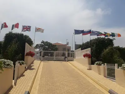 a fence with many flags flying over a walkway at ANTHORINA VILLA 9 in Protaras