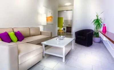 a living room with a couch and a table at Napian Suites in Ayia Napa
