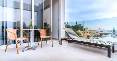 two chairs and a table on a balcony with a view at Napian Suites in Ayia Napa