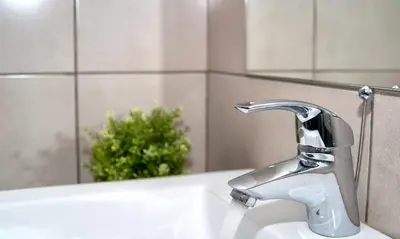 a bathroom sink with a silver faucet and a mirror at Napian Suites in Ayia Napa