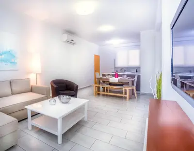 a living room with a couch and a table at Napian Suites in Ayia Napa