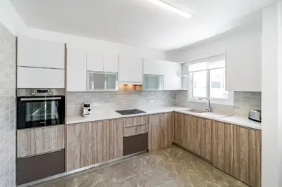 a kitchen with wooden cabinets and white appliances at Beach Front Aqua Marina by Ezoria Villas in Paralimni