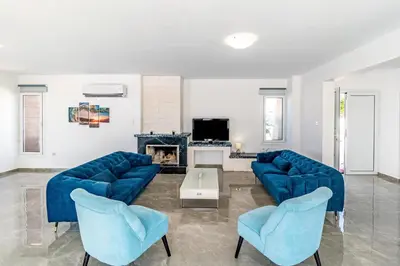 a living room with two blue couches and a fireplace at Beach Front Aqua Marina by Ezoria Villas in Paralimni