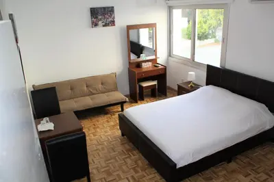 a bedroom with a bed and a couch and a mirror at Eclectic Business & Leisure in Nicosia