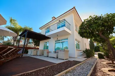 a villa with a dining area in front of a house at Beach Front Bella Vista by Ezoria Villas in Protaras