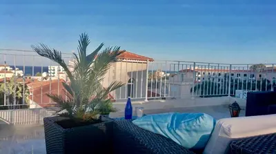 a balcony with a palm tree and a view of a city at Palma Villa 14 in Protaras