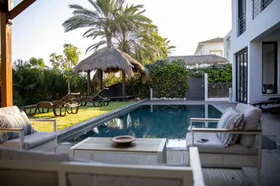 a backyard with a swimming pool with chairs and a table at Balinese in Ayia Napa