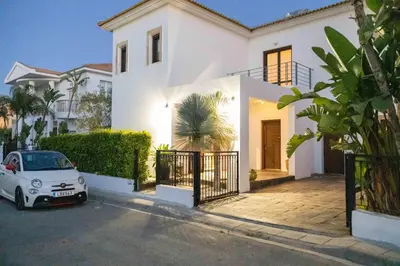 a white house with a car parked in front of it at Balinese in Ayia Napa