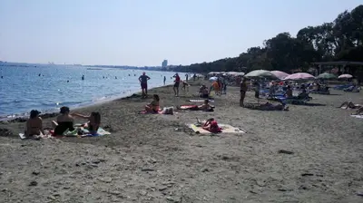 a group of people sitting on a beach at Chrysanthos Boutique Apartments in Limassol