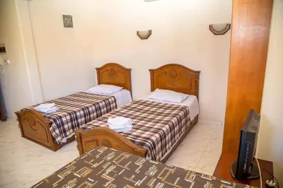 a hotel room with two beds and a television at Chrysanthos Boutique Apartments in Limassol