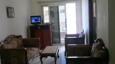 a living room with two chairs and a couch and a tv at Chrysanthos Boutique Apartments in Limassol