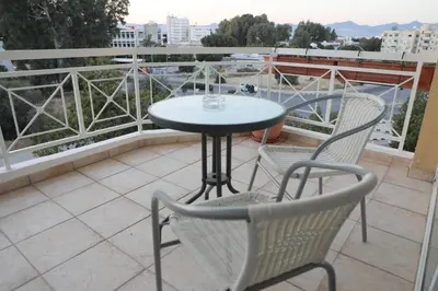a table and two chairs on a balcony at Bianco E U Apartment in Nicosia