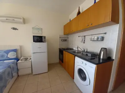 a small kitchen with a washing machine and a sink at Montehugh in Larnaka
