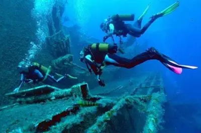 two people diving into the ocean near a reef at The White House in Larnaka