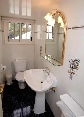 a white bathroom with a sink and a toilet at The White House in Larnaka