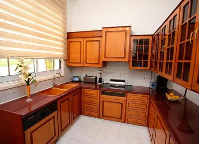 a kitchen with wooden cabinets and a sink and a window at The White House in Larnaka