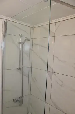 a shower with a glass door in a bathroom at Kolonaki Seaview Apartments in Larnaka