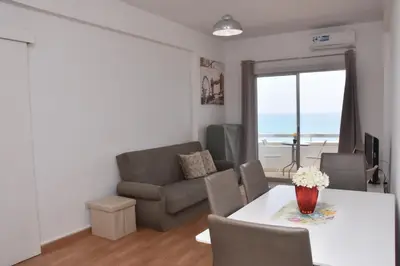 a living room with a table and a couch at Kolonaki Seaview Apartments in Larnaka